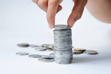 Human hands stacking coins on white background, studio shot