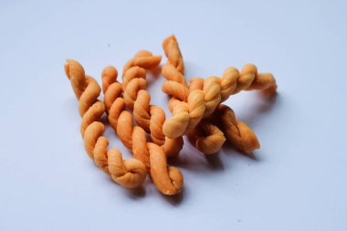 Traditional cakes or commonly called Untir untir are traditional Indonesian cakes made from wheat flour, sugar, eggs, and sesame seeds on a white background.