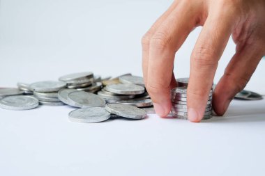 Human hands stacking coins on white background, studio shot