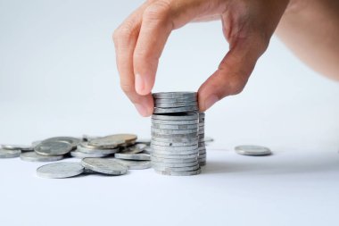 Human hands stacking coins on white background, studio shot