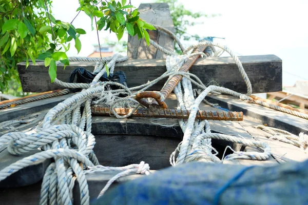 Anchor fisherman on the front of the boat with a big rope on a green leaf background