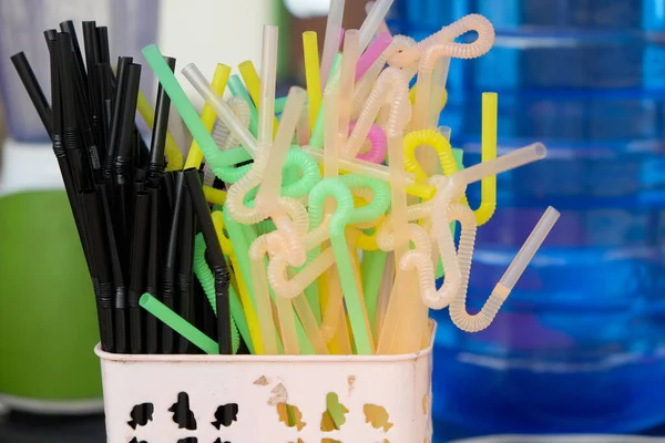 Various colorful plastic drink straws in the container