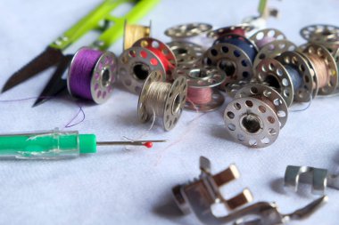 Dikiş aletleri, renkli iplik makaraları, makas ve dikiş makinesi ayakkabıları. Terzilik endüstrisi