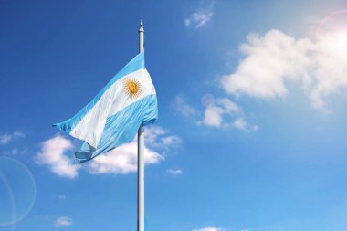 Argentinian flag waving on a blue sky with copy space.