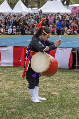 Buenos Aires, Arjantin - 25 Eylül 2022: Genç Japon kadın güneş selamı veriyor. Eisa (Japonca davulla dans) Varela Matsuri 'de.