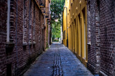 Cobblestone Caddesi, Tarihi Charleston SC. Bu eski caddenin dengesi gözüme takıldı yolun ortasına doğru giden saf kaldırım hattıyla. Resimde dengeyi bulmanızı sağlıyor ve sarı ve doğal tuğlaları vurguluyor..