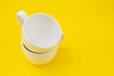 Sarı arkaplanda boş yeni beyaz fincan