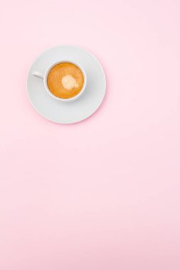 Pembe arka planda bir fincan kahve