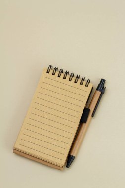 Kahverengi arkaplanda kalem olan not defteri