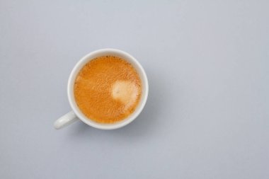 Beyaz fincanda gri arka planda kahve.