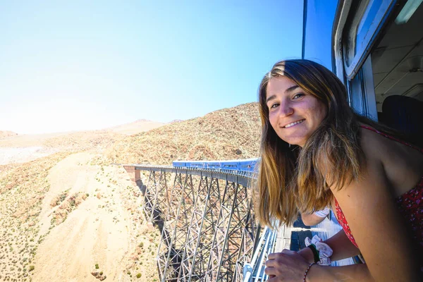 Кавказька Жінка Вікном Посміхається Дивиться Камеру Подорожуючи Потягом Через Пустельні — стокове фото