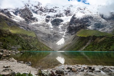 Ortasında kristal bir göl olan karlı dağın geniş açısı. Yatay olarak. Kopyalama alanı olan. Humantay Gölü.