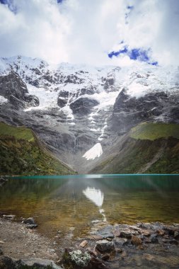 Ortasında kristal bir göl olan karlı dağın geniş açısı. Dikey. Kopyalama alanı olan. Humantay Gölü.