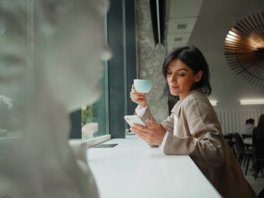 Kafede uzaktan eğitim, çevrimiçi eğitim veya video sohbeti yapan Müslüman kadın