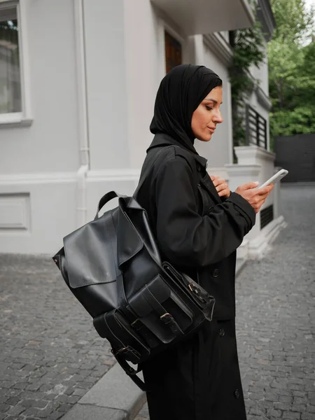 Snygg muslimsk kvinna med hijab promenader och ha telefonsamtal på gatan — Stockfoto