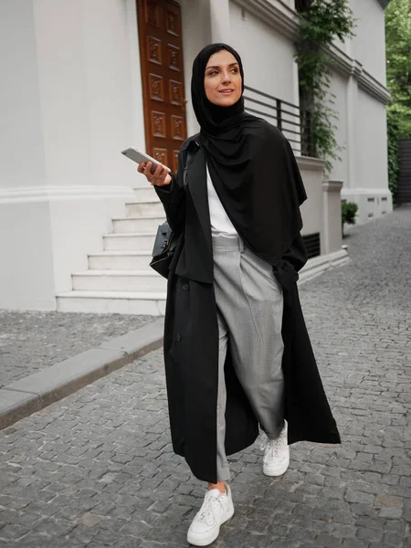 Snygg muslimsk kvinna med hijab promenader och ha telefonsamtal på gatan — Stockfoto