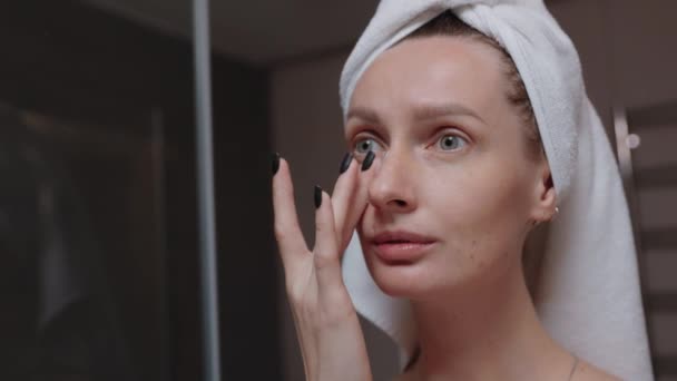 洗澡镜前 女人头上裹着毛巾 涂上润肤霜 日常晚间活动 面部清洁 剥皮美容治疗概念 — 图库视频影像
