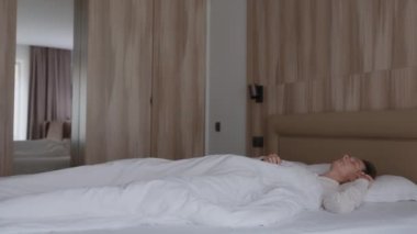 Tembel bir hafta sonu. Zarif pijamalı, uykulu, beyaz bir kadın uyanıyor. Yastığı açıyor, gülümsüyor ve yatakta geriniyor. Yeni gün tebrikleri ve sabah erkenden konforlu dairede eğlenmek..
