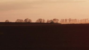 Traktör sahada çalışıyor. Tarım işi, çiftçiler çalışma sürecinde. Tarım, makine, toprak gübreleme ve organik bitki yetiştirme kavramı. Arkaplan kopyalama alanı 