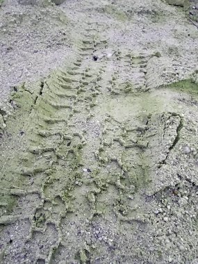 İnşaat alanındaki bir kum yığınında lastik izleri..