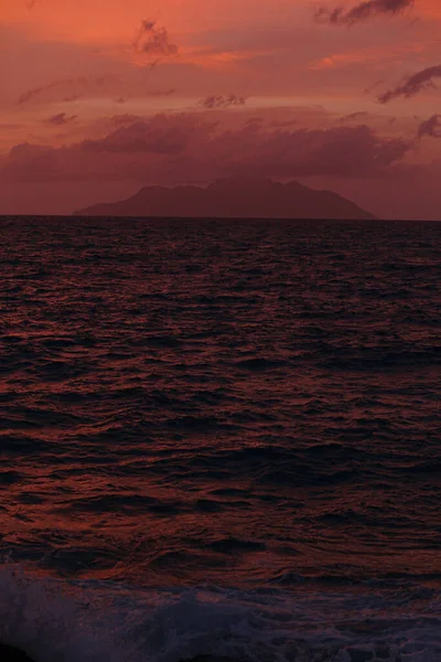 Ocean at sunset, mountains on the horizon. — Stock Photo, Image