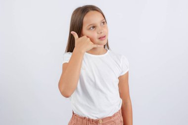 Kız elini kulağına dayadı ve bir telefon görüşmesi hayal etti. Yüksek kalite fotoğraf