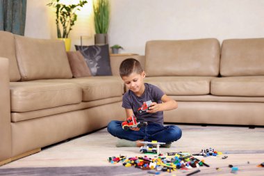 Evde yerde oturmuş lego oynayan çocuk. Yüksek kalite fotoğraf 