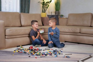 İki kardeş oturur ve tasarımcının oyuncaklarını gösterir. Yüksek kalite fotoğraf