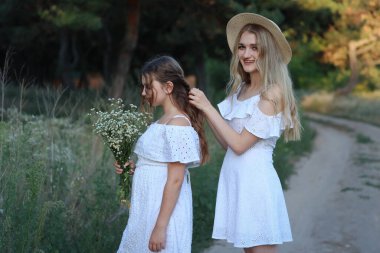 older sister braiding younger sisters hair. High quality photo