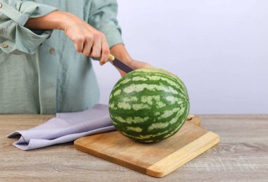 Womans hands cut a watermelon on a board. High quality photo