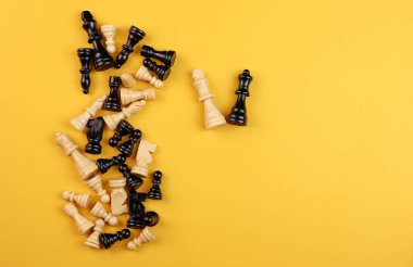 Satranç taşları rastgele sarı arka planda yatar. Yüksek kalite fotoğraf