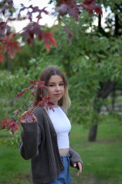 Parktaki kız dalların arasından bakıyor. Yüksek kalite fotoğraf