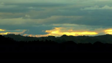 Gün batımında güzel, karanlık bir zemin, bulutlar pürüzsüz ve hızlı uçar Yavaş çekim statik kamera