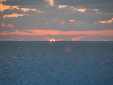 Güneş batarken denizin üzerinde.