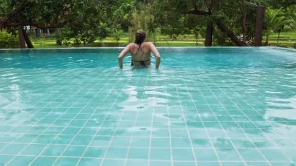 Woman Sits Edge Pool Swims Backdrop Tropical Vegetation Hotel Villa — Vídeo de Stock