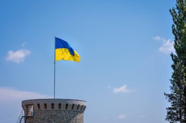 Mavi gökyüzünde izole edilmiş Ukrayna bayrağı. Ukrayna bayrağını sallayarak yaklaşın. Ukrayna 'nın bayrak sembolleri.