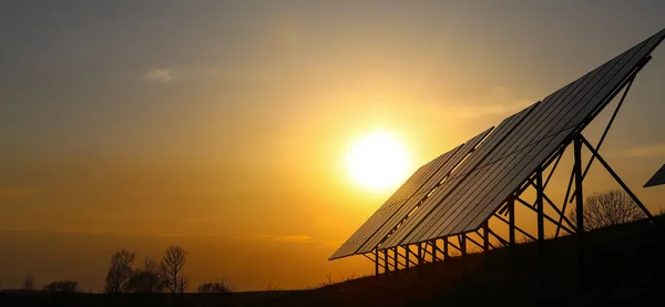 Fotovoltaik bataryalar turuncu gün batımında. Güneş panelleri. Alternatif enerji kavramı