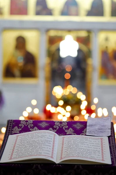 Açık kilise ortodoks kitabı kilise dilinde yanan mumlar ve dini imgelerin arka planına karşı yazılmıştır. Ortodoksluk kavramı.