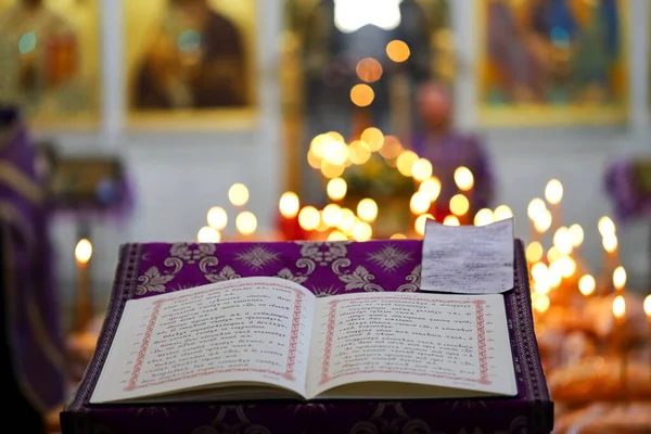 Açık kilise ortodoks kitabı kilise dilinde yanan mumlar ve dini imgelerin arka planına karşı yazılmıştır. Ortodoksluk kavramı.