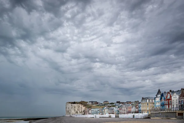 Colored houses along side the coast line of Mers-les-Bains in Normandy France under a grey cloudy sky