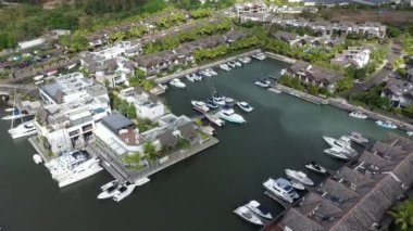 Yatlar ve tekneler, Mauritius Adası 'ndaki La Balise Marina' daki lüks evlerin yakınına park edilmiştir.