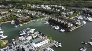 Yatlar lüks evlerin yakınına park edilmiş. Grande Riviere Noire 'deki La Balise Marina, Mauritius Adası