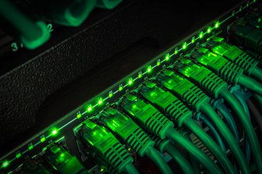 Yama kablosuna bağlı veri merkezinden karanlıkta parlayan yeşil ağ kablolarını kapat