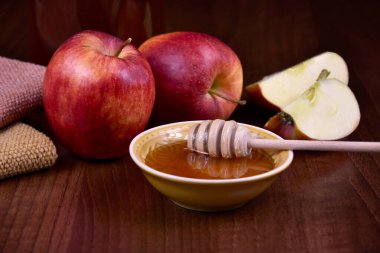Rosh Hashanah hala elma ve bal aromalı görüntülerle yaşıyor. Masanın üzerinde kırmızı elmalı bir kase bal var. Yahudi Yeni Yıl Rosh Hashanah tebrik kartı. Önemli bir gün.