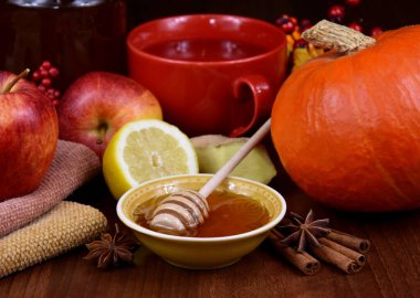 Ballı, elmalı, balkabaklı, zencefilli ve çay stoklu resimli bir sonbahar hayatı. Bir kase ballı, limonlu, kırmızı elmalı, zencefilli, kabaklı. Hasta görüntülerde sağlıklı yiyecekler