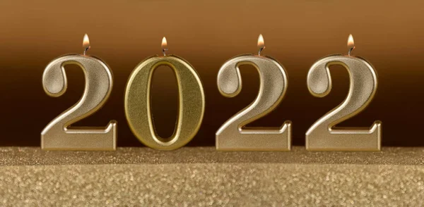 2022 New Year burning golden candles stock images. Number 2022 New Year on a golden festive background photo images