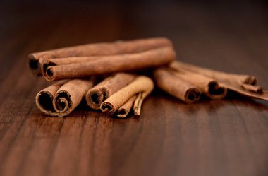 Kokulu tarçın desenli görüntüler sunar. Ahşap bir arkaplanda tarçın çubukları.