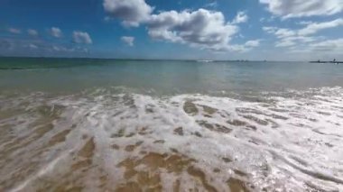 Meşhur Waikiki sahilinin sarı kumlarında yürüyorum. Pasifik Okyanusu 'nun sıcak dalgaları tropik bir Waikiki plajını kaplıyor. Elmas başlı yanardağın arka planına karşı turkuaz su