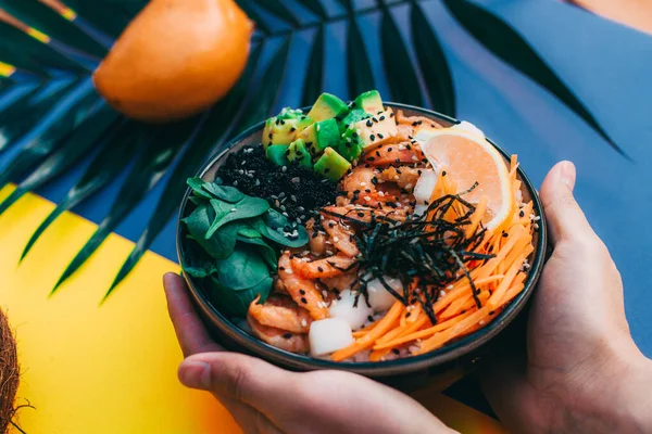 Tazón poke con camarones celebrada en el fondo de una ramita verde y mango — Foto de Stock