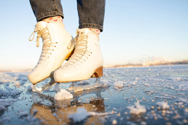 современные фигурные коньки, одетые для девушки. крупный план фигурного катания на озере с чистым льдом